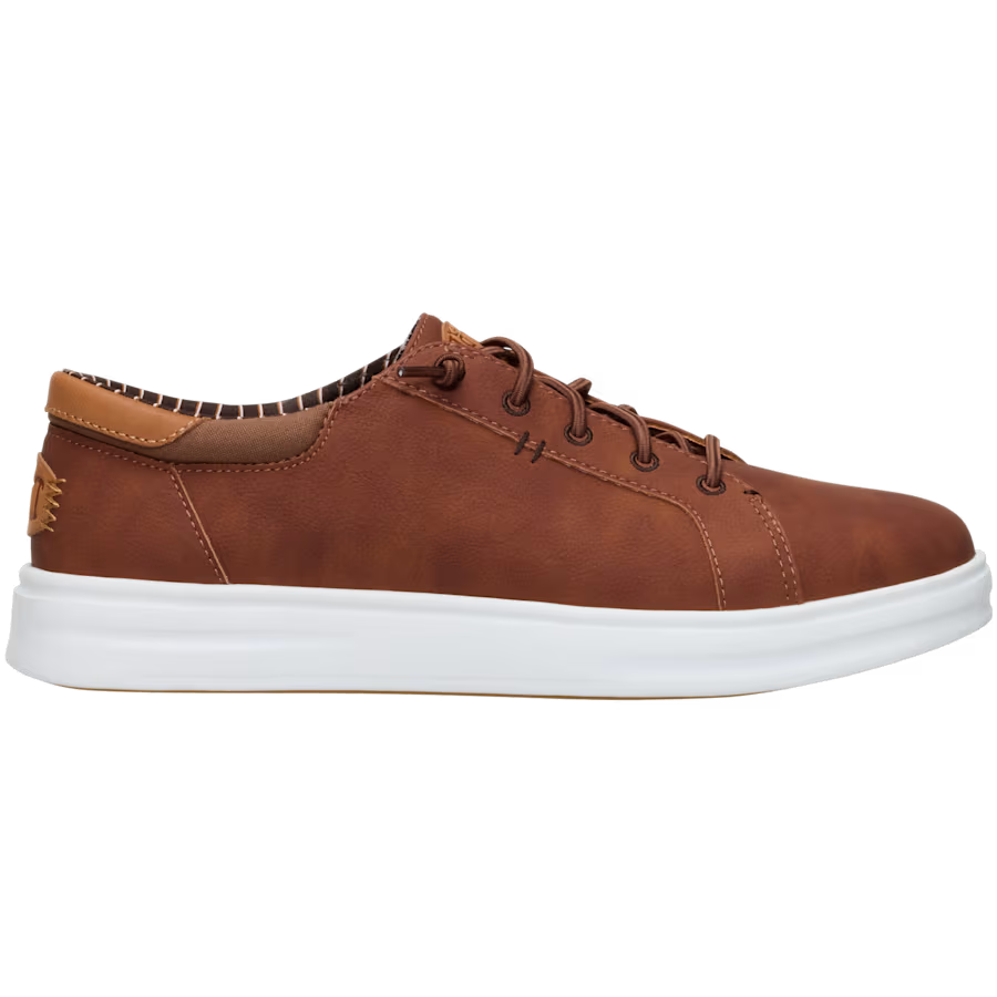 A brown sneaker with white sole, laces, and a leather heel pull tab.