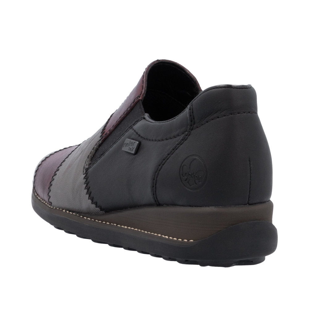 Slip-on shoe with a low heel, made of black leather with patches of purple and gray leather.