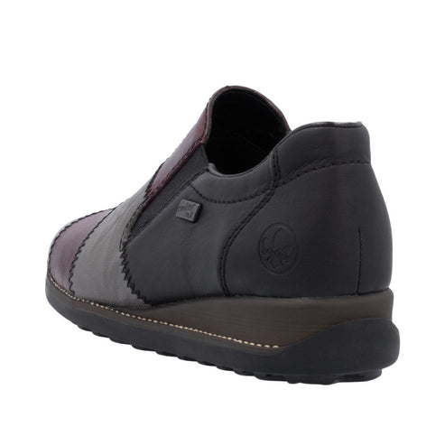 Slip-on shoe with a low heel, made of black leather with patches of purple and gray leather.