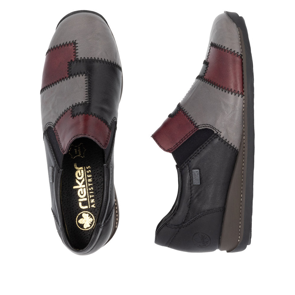 Pair of patchwork-design shoes in gray, black, and burgundy with 'Rieker Antistress' logo visible on the insole.