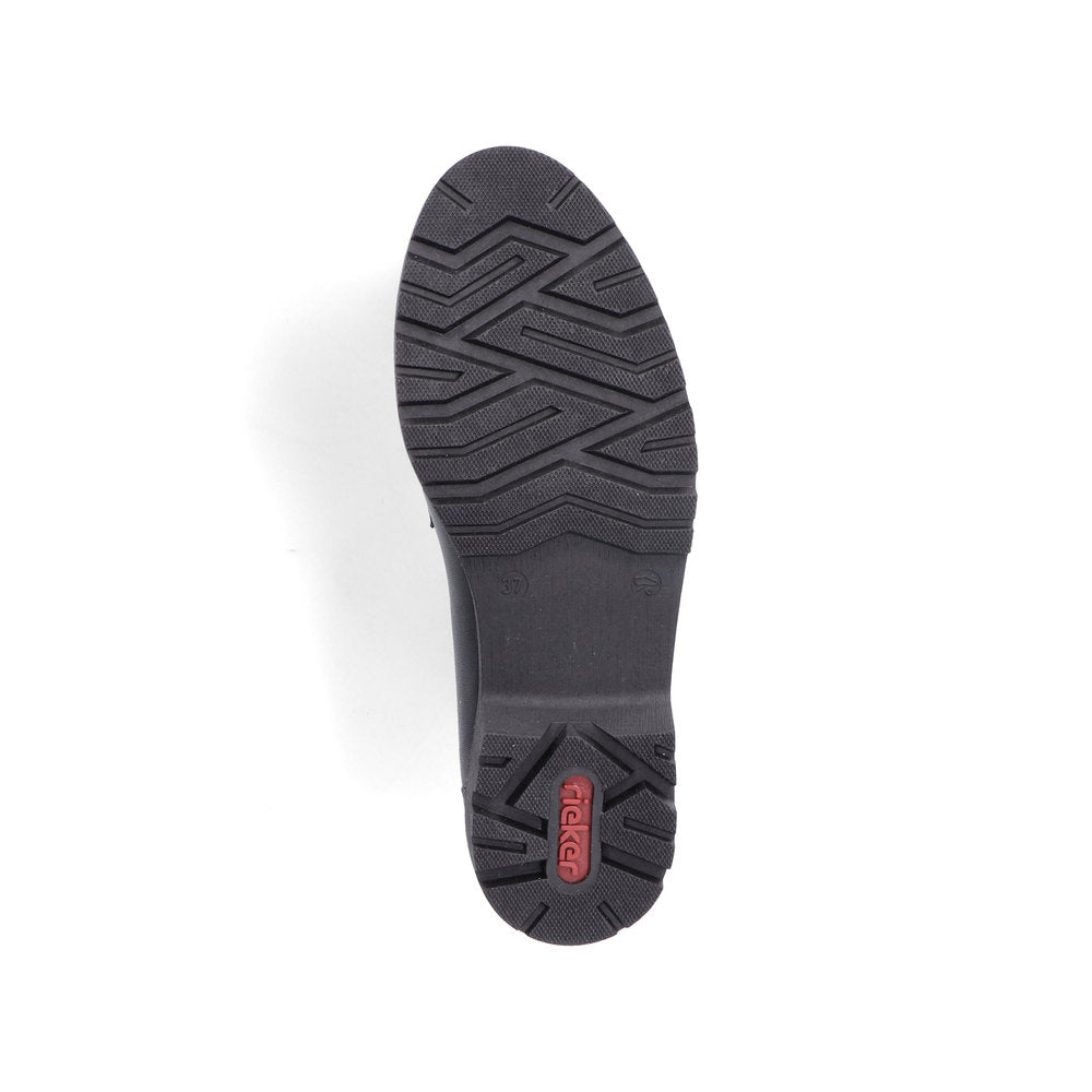 The bottom sole of a dark-colored shoe with a textured pattern and the text 'Rieker' visible.