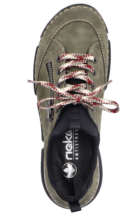 Top-down view of a khaki low-top sneaker with a side zipper and thick laces. The insole is black with "RIEKER ANTISTRESS" printed on it.