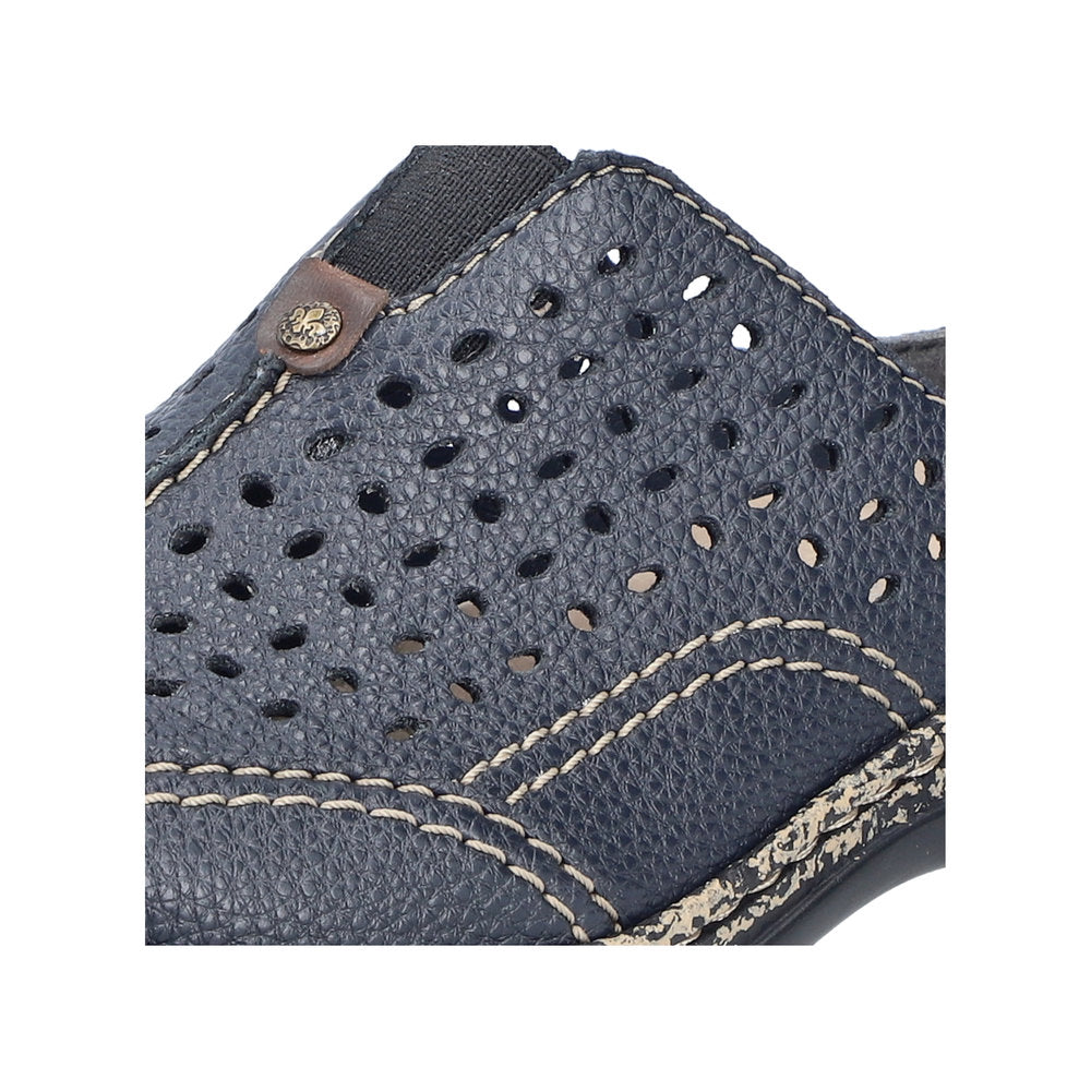 Close up view of a navy blue leather perforated shoe with brown leather accent.