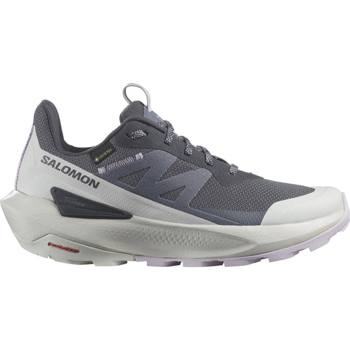 A trail running shoe with gray breathable mesh, gray Gore-Tex label, white heel cup with SALOMON text, and an aggressive off-white sole.