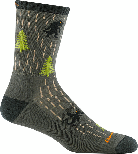 Green sock with an illustration of a bigfoot silhouette, bright green pine trees, and light tan dashes.