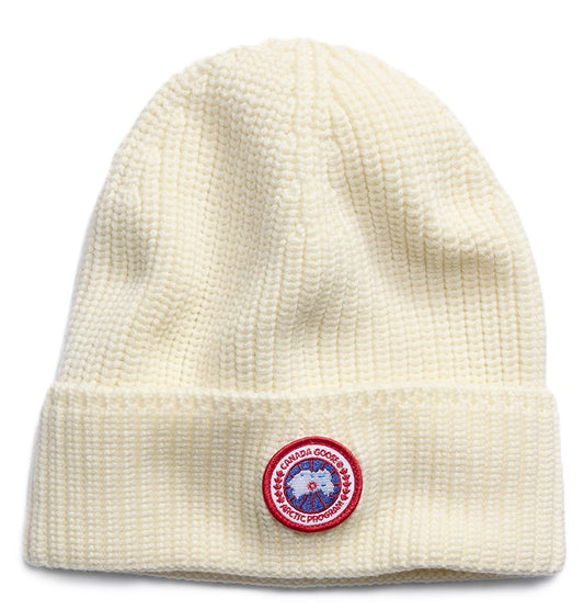 White knit beanie with a red, white, and blue logo patch.