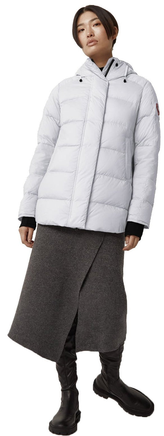 A model wearing a grey puffer jacket, a gray midi skirt, and black boots.