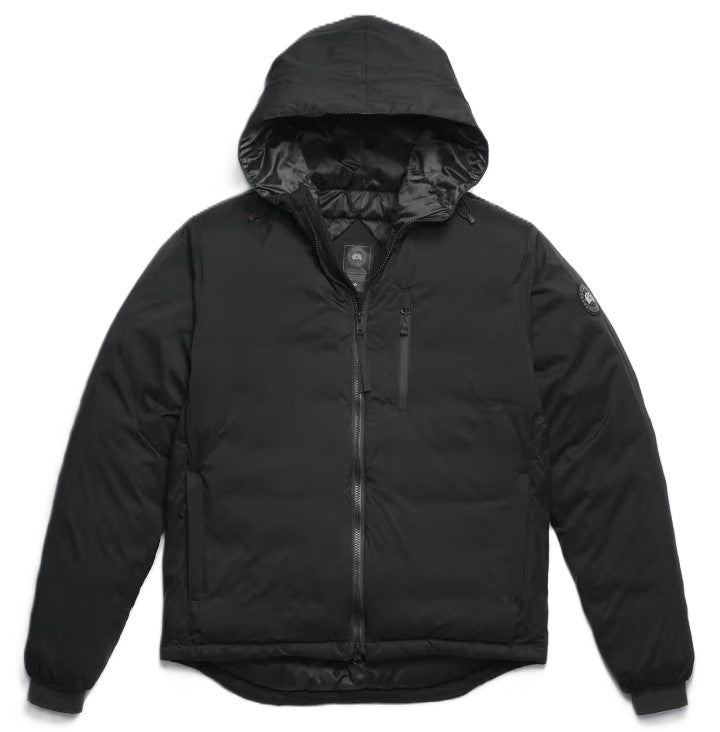 A black, insulated puffer jacket with a hood, a front zipper, a chest pocket, and a small round logo patch on the left upper sleeve.