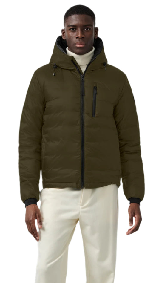 A person wearing a green down-filled hooded jacket and off-white pants.