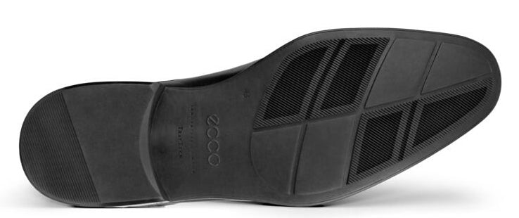 The black rubber sole of a shoe with a geometric pattern.