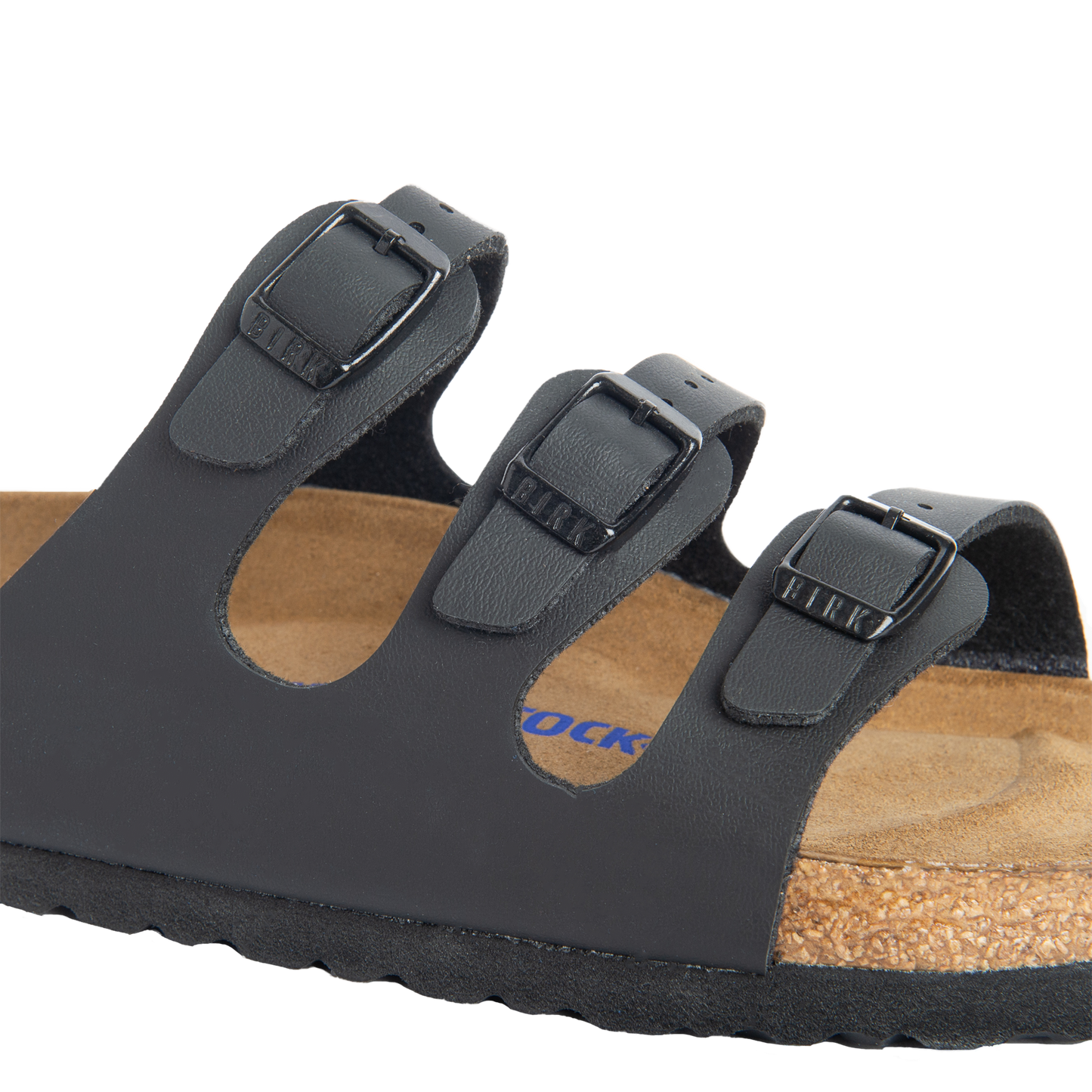 Close-up of a black sandal with three straps and adjustable buckles.