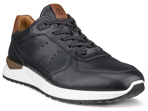A black leather sneaker with brown accents on the heel and tongue, featuring a thick white midsole and a black treaded outsole.