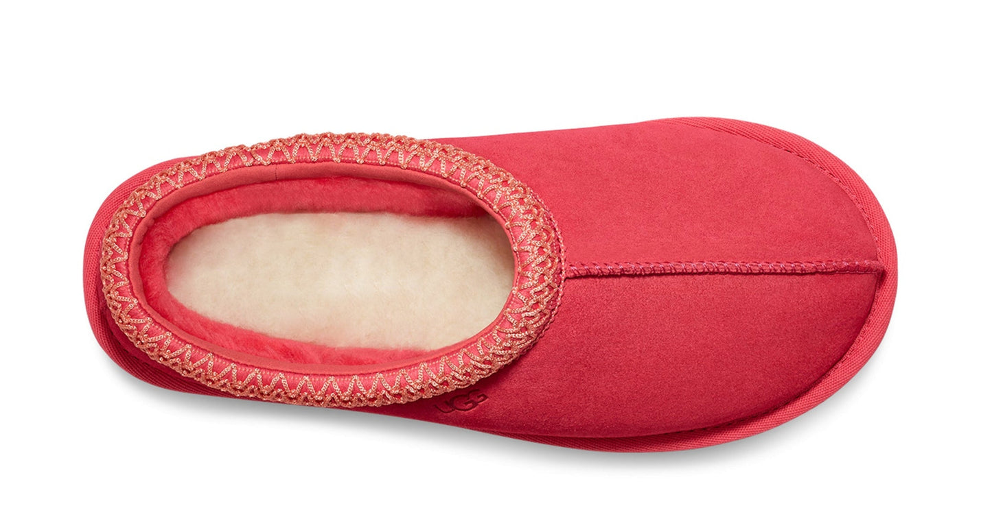 One coral-colored, fuzzy slipper with a rounded toe and contrasting trim.