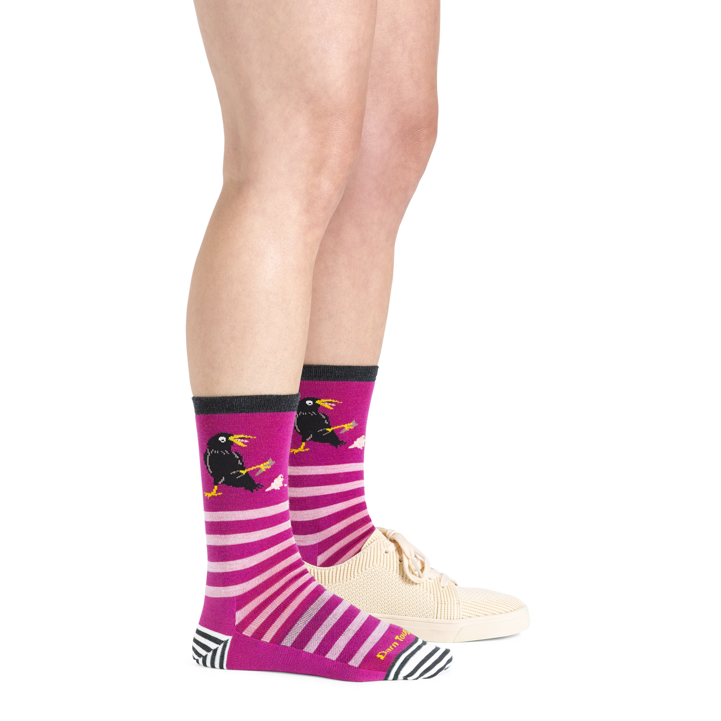 Model wearing fuchsia and white striped socks with crow design.