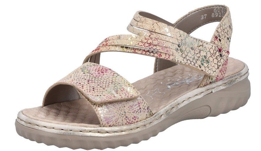 Beige sandal with textured, floral straps and a low wedge heel.