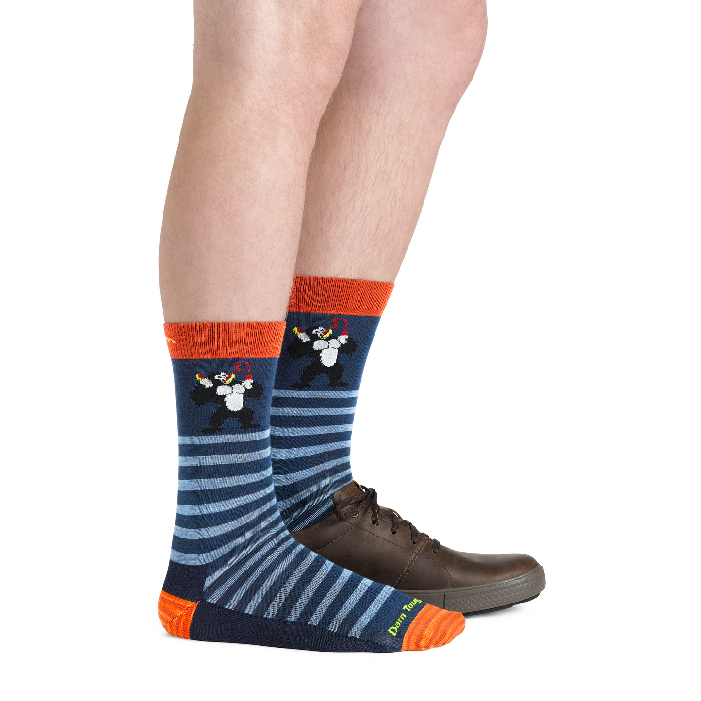 Person wearing socks with mole and striped pattern paired with brown shoes.