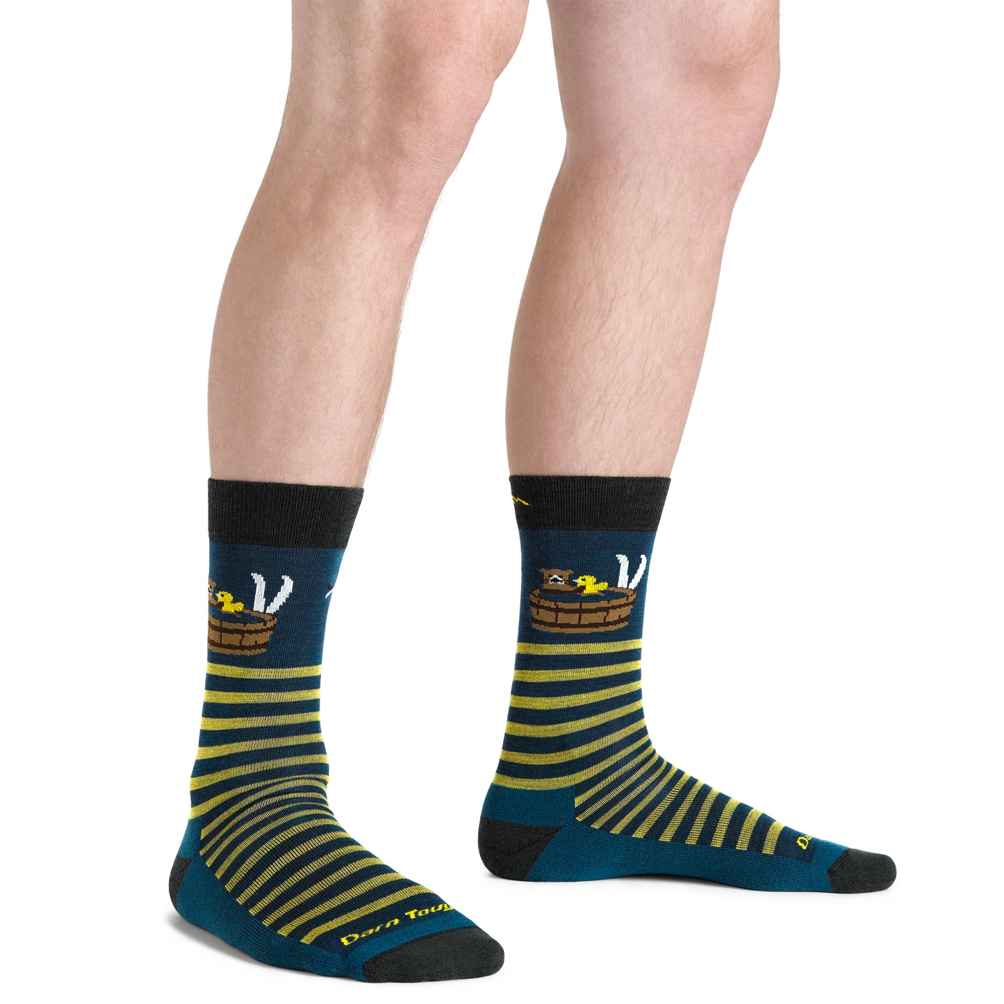 Person wearing socks with a yellow striped barrel, white cat, and yellow duck design on navy blue, along with the text "Don't Touch" at the toe.