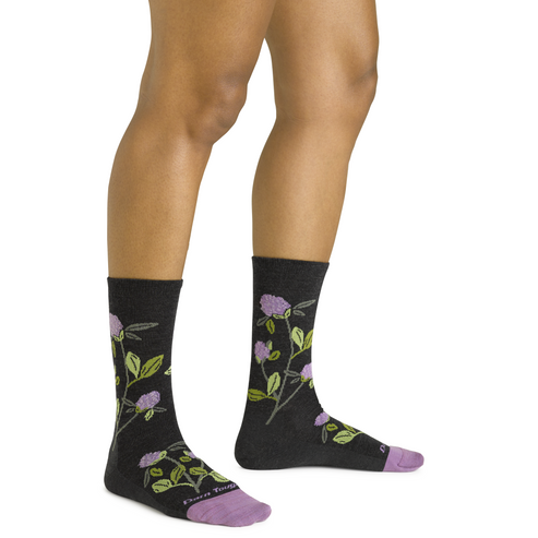 Pair of socks featuring floral designs on a black background with lavender toes and heels.