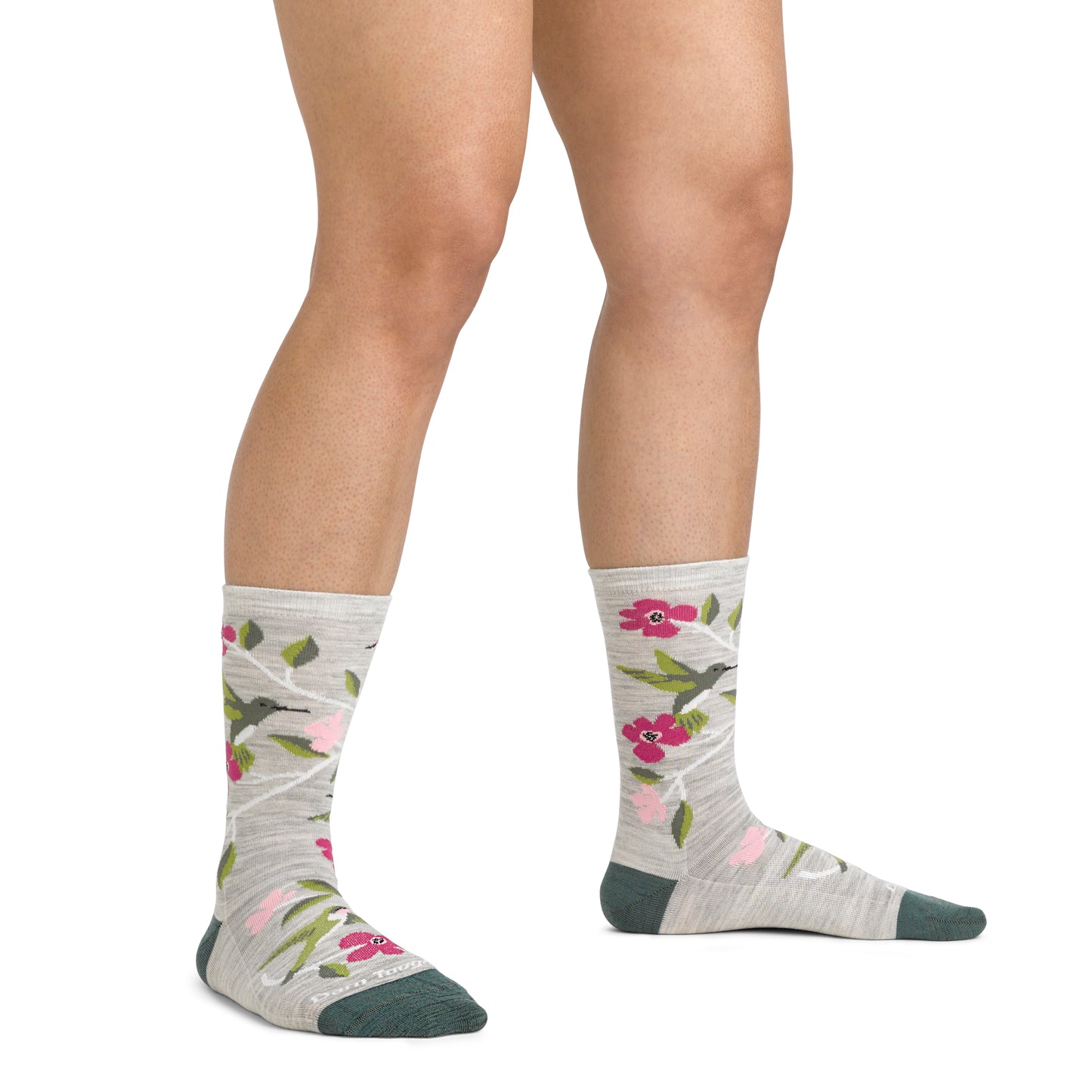 Person wearing calf-high socks with hummingbird and floral pattern.