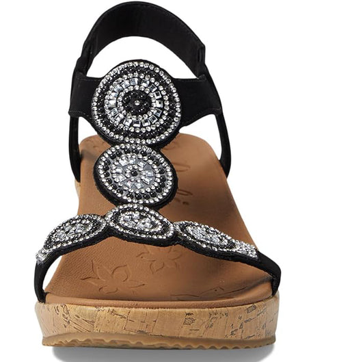 Black wedge sandal with circular silver beaded embellishments.