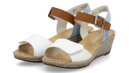 Pair of wedge sandals with white toe straps, brown and blue ankle straps, buckle closure, and braided jute trim.