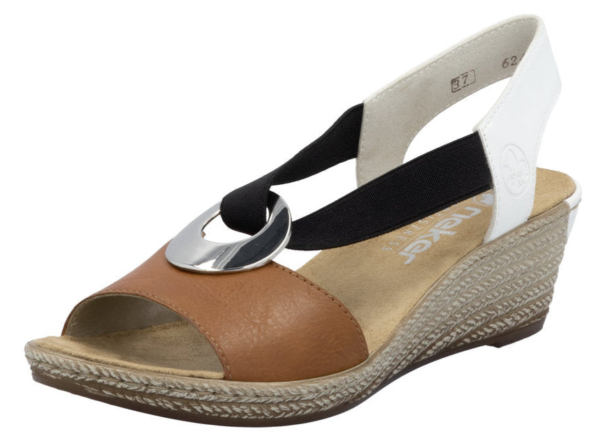 Tan sandal with wedge heel, black and white elastic straps, and a silver ring detail.