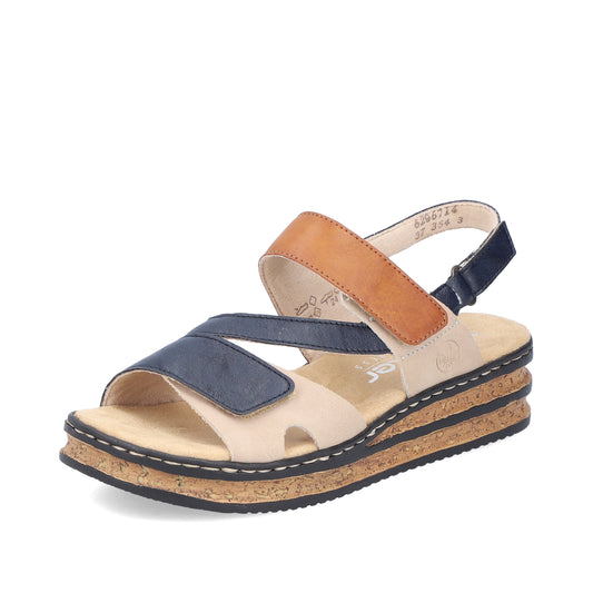Sandals with beige base, black outsoles, cork platforms, and two-tone straps of blue and tan.
