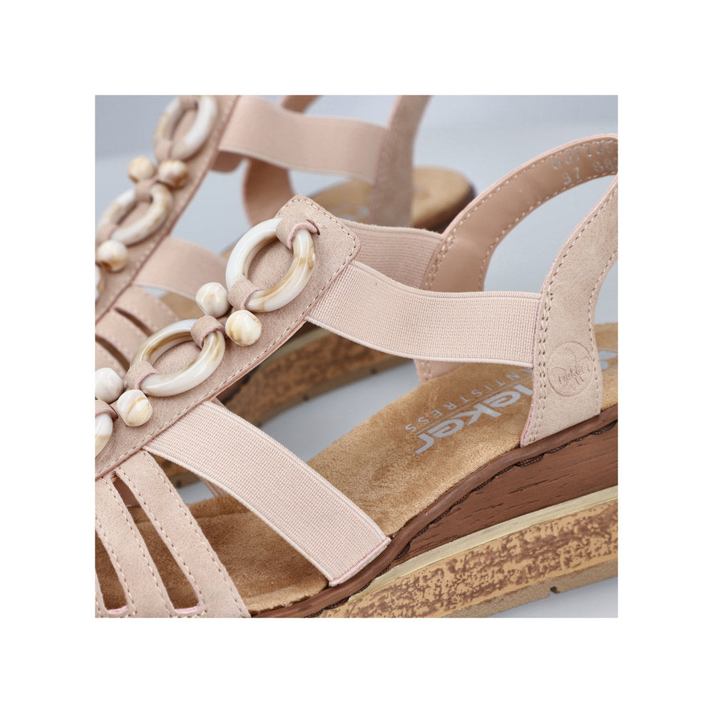 Beige sandal with white round beads and elastic straps.