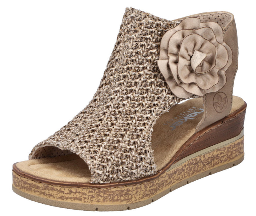 Beige peep-toe wedge sandal with flower accent and textured upper.