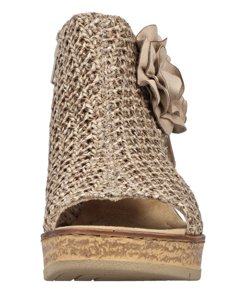 Tan peep-toe wedge heel shoe with flower accent.