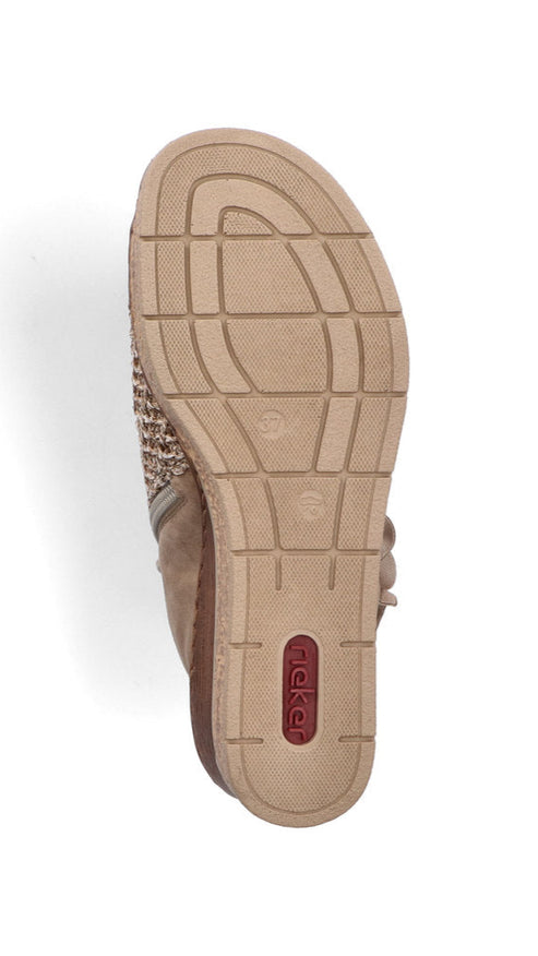 Bottom of beige shoe with dark red logo on sole.