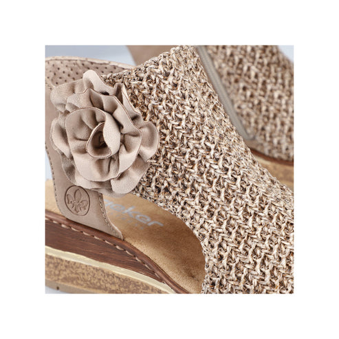 Close-up of beige woven sandal with flower decoration.