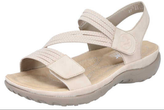 Beige sandal with criss-cross straps and velcro closures.