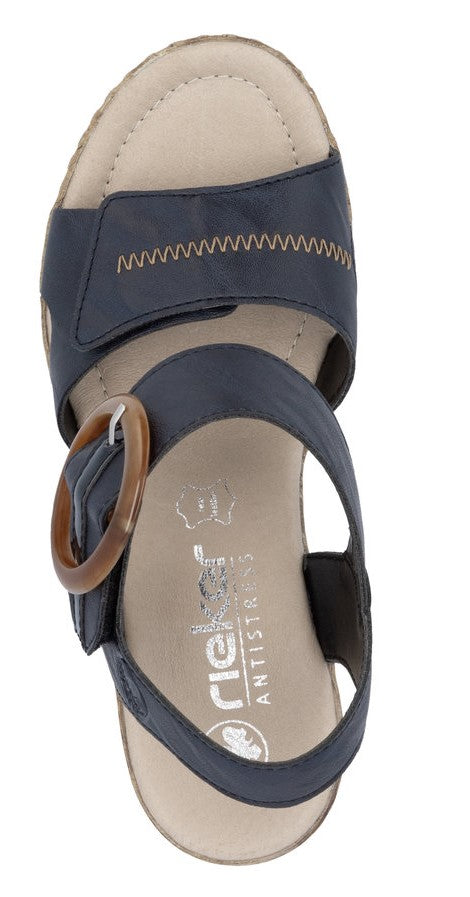 Navy sandal with ankle strap and large circular side buckle.