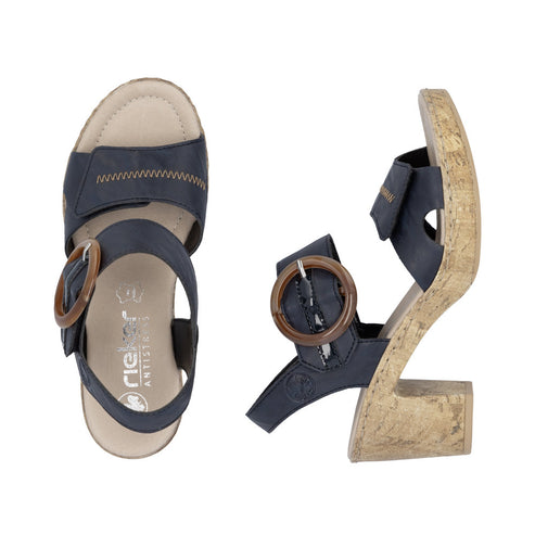 Navy sandals with a brown circular buckle and visible text 'rieker ANTISTRESS' on the inner sole.