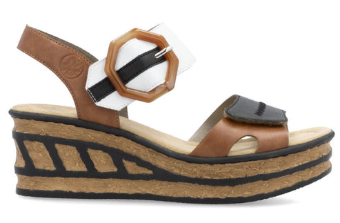 Platform sandal with stacked cork wedge heel, brown, white, and black upper with large buckle.