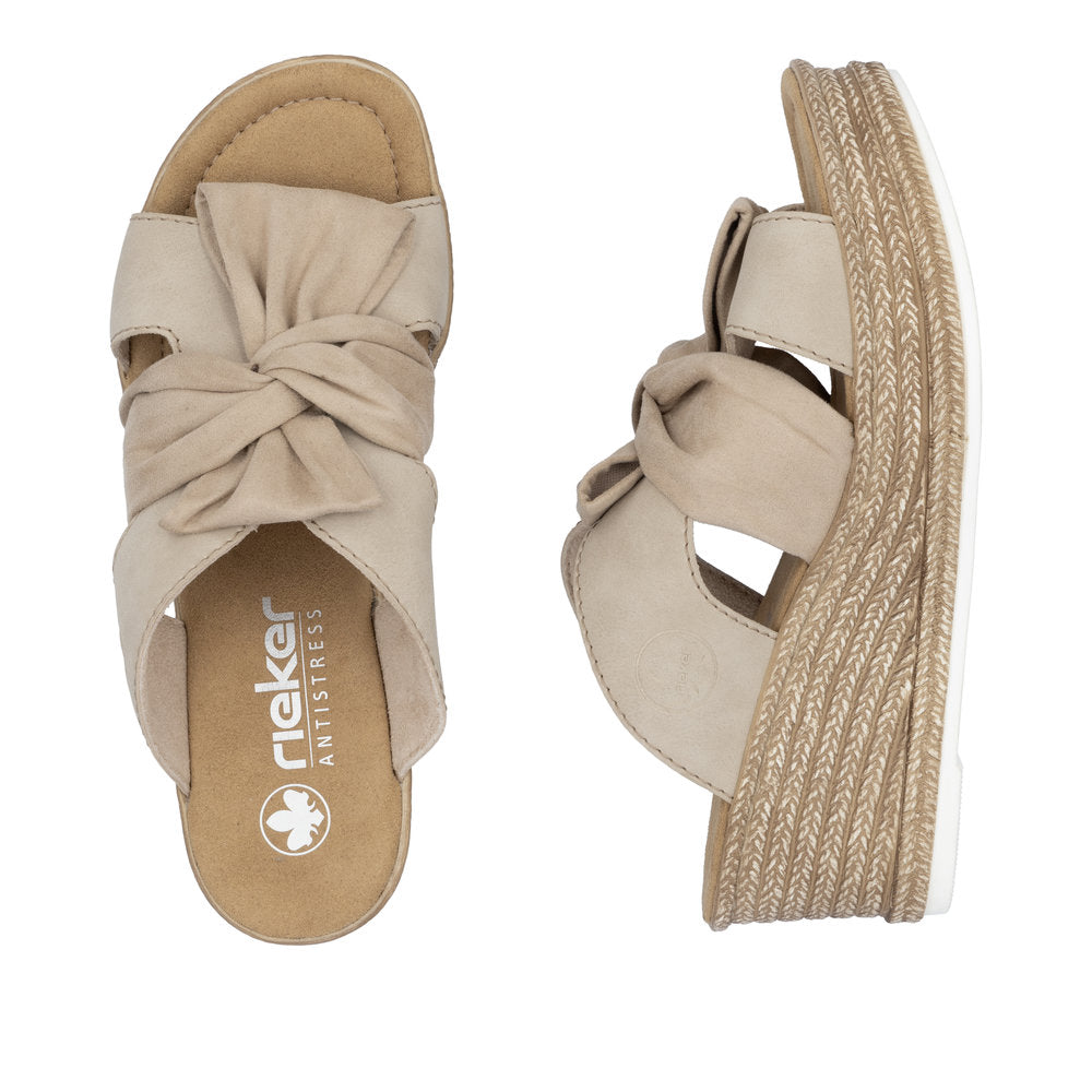 Beige rieker sandal with a knotted front strap and wedge heel.