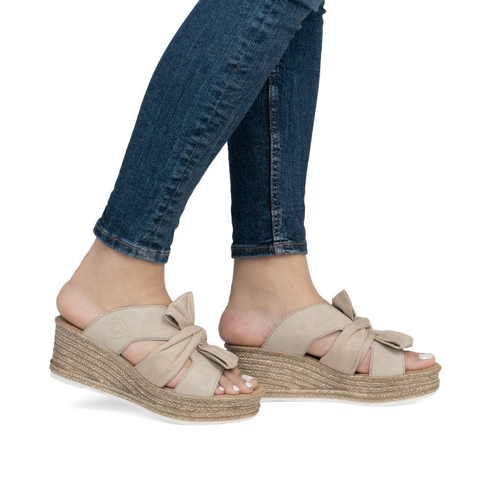 Pair of tan wedge sandals with bow detail.