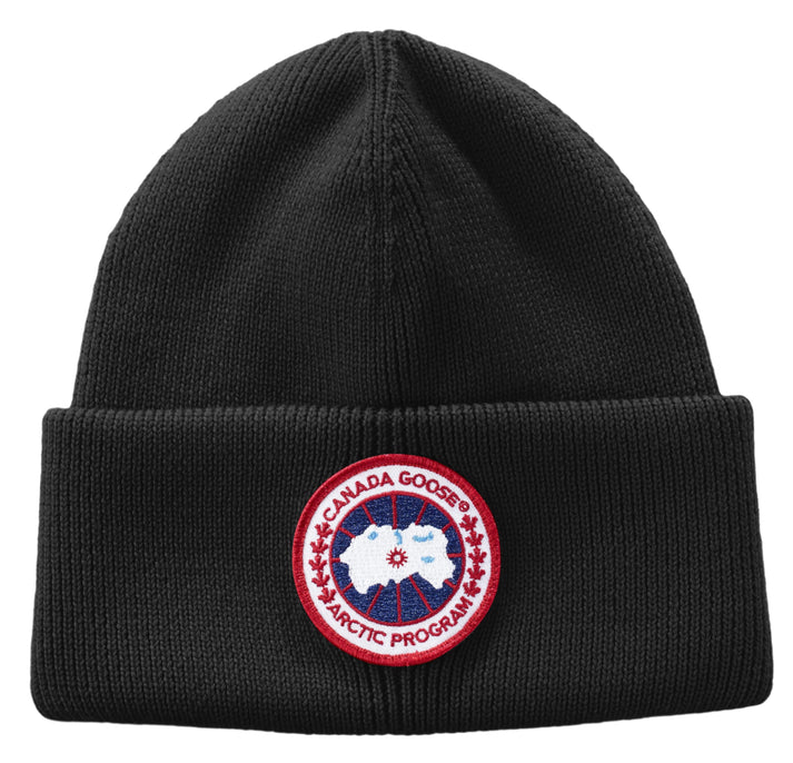 Black knit beanie hat with a circular patch of a map inside a red circle with text 'CANADA GOOSE ARCTIC PROGRAM'.