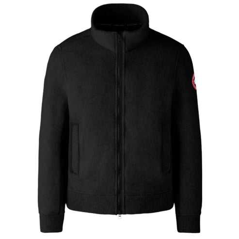 Black zippered jacket with a high collar and a round logo on the arm.
