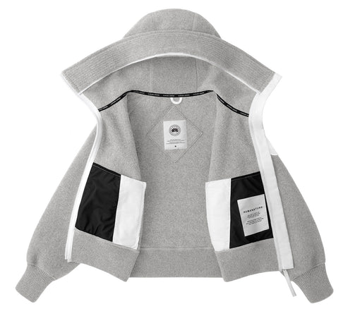 Open, gray hooded sweatshirt with black and white pockets; a white tag with black text is visible.