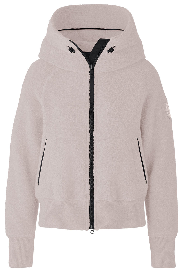 A light beige, plush fleece zip-up hooded jacket with a black front zipper and black trim on the pockets and hood drawstrings, featuring ribbed cuffs and a cropped silhouette.