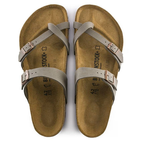 Pair of taupe sandals with criss-cross straps and adjustable buckles.