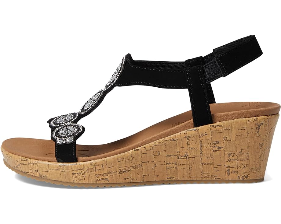 Black sandal with wedge heel, faux cork texture, decorative silver accents, and adjustable ankle strap.