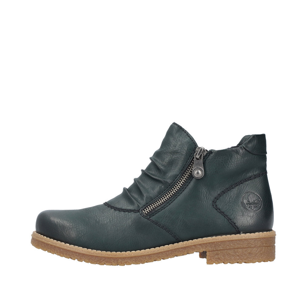 Ankle boot in dark green leather with a zipper on the side and a brown sole.