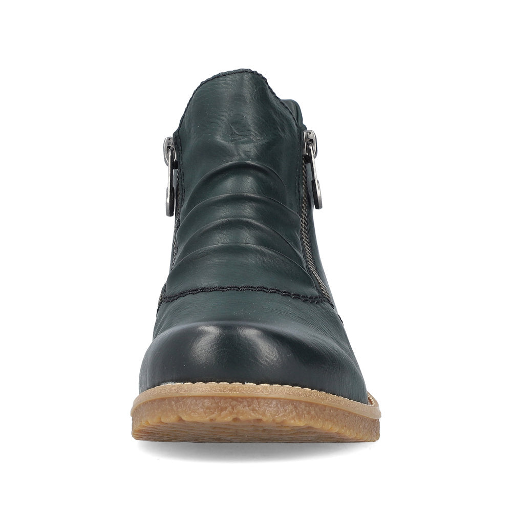 Front view of a dark green ankle boot with side zippers and a tan sole.