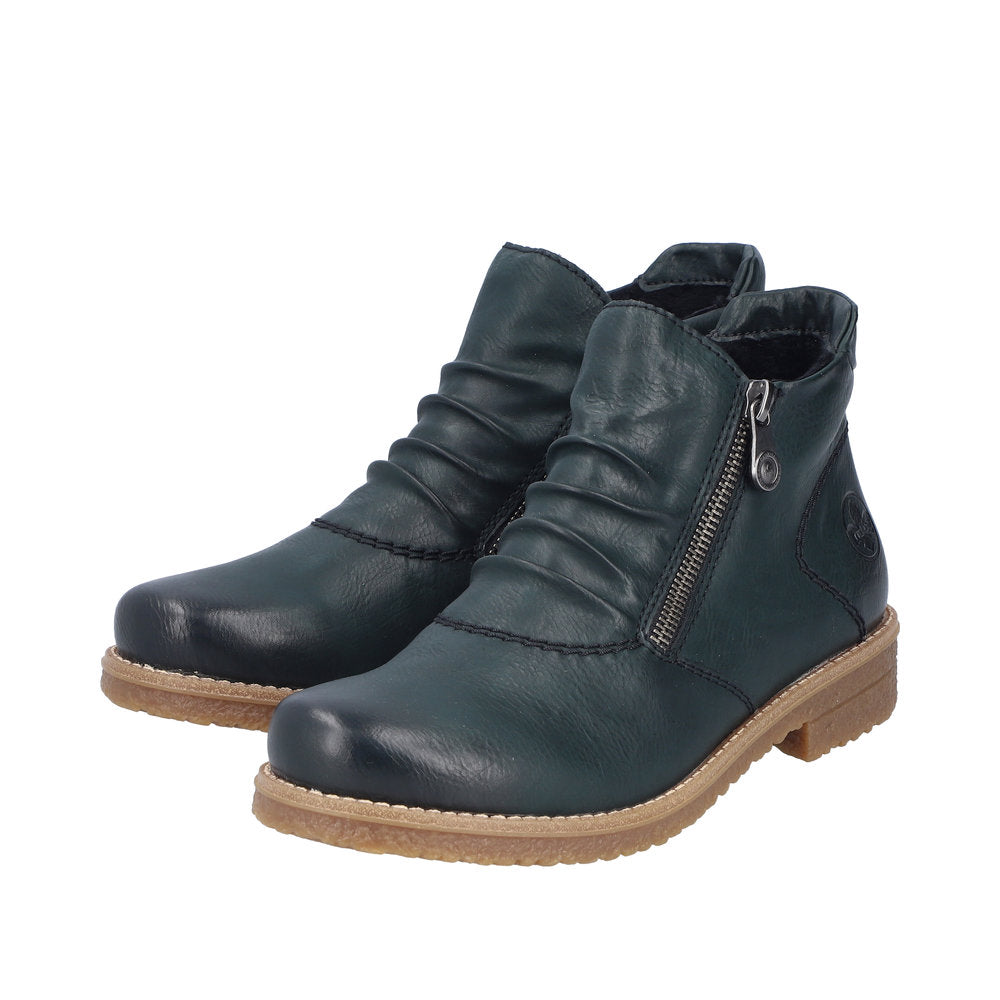 Pair of dark green ankle boots with side zipper, and scrunched vamp, on a tan sole.