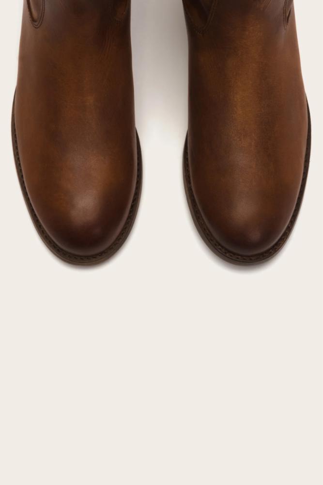 Close up of the toes of two brown leather boots.