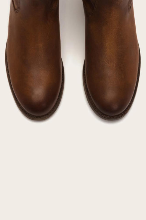 Close up of the toes of two brown leather boots.