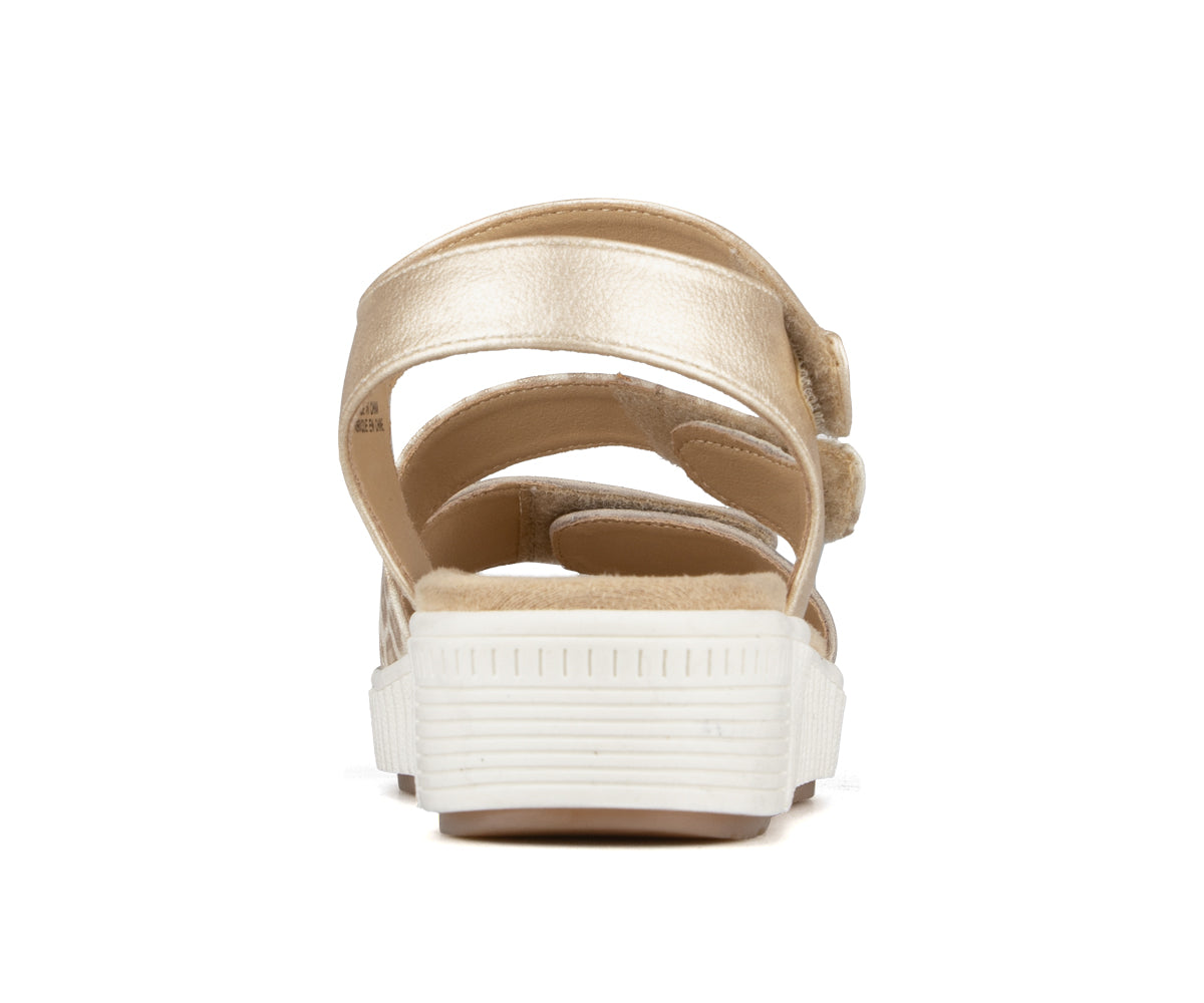 Gold, back view of platform sandals with adjustable hook and loop straps.